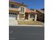 Stucco home with a two-car garage, red tile roof, and manicured front yard on a sunny day at 5024 Saint Annes Dr, Las Vegas, NV 89149