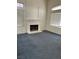 A spacious living room with a cozy fireplace, natural lighting, and neutral color carpeting at 5024 Saint Annes Dr, Las Vegas, NV 89149