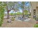 Backyard with desert landscaping, trees, and lounge chairs at 512 Pima Canyon Ct, Las Vegas, NV 89144