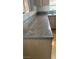 Close-up of a long countertop featuring dark beige granite with wood-stained cabinets at 5250 S Rainbow Blvd # 1140, Las Vegas, NV 89118