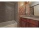 Nicely tiled bathroom showcasing a tub and vanity with granite countertop at 5383 Indian River Dr # 323, Las Vegas, NV 89103