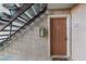 Condo front door in neutral brown with dark metal hardware, stairs to left and exterior apartment number at 5383 Indian River Dr # 323, Las Vegas, NV 89103