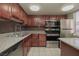 Modern kitchen featuring stainless steel appliances, granite countertops, and dark wood cabinetry at 5383 Indian River Dr # 323, Las Vegas, NV 89103