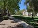 Landscaped common area with a paved walkway, green grass, and mature trees between buildings at 555 E Silverado Ranch Blvd # 2052, Las Vegas, NV 89183