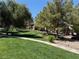 Beautifully landscaped green space with mature trees and walking path through the community at 555 E Silverado Ranch Blvd # 2052, Las Vegas, NV 89183