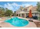 Picturesque backyard features a sparkling pool, spa, and covered patio seating area at 56 Grossinger Ct, Henderson, NV 89074
