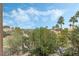 Peaceful backyard view featuring lush greenery, palm trees, and glimpses of a swimming pool at 56 Grossinger Ct, Henderson, NV 89074