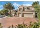 Two-story home with neutral color palette, terracotta driveway and three-car garage is beautifully landscaped at 56 Grossinger Ct, Henderson, NV 89074