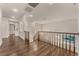 Upstairs hallway with hardwood floors and wooden railing overlooks a staircase and main living areas at 56 Grossinger Ct, Henderson, NV 89074