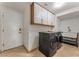 Well-equipped laundry room with modern washer and dryer, storage cabinets, and a utility sink at 56 Grossinger Ct, Henderson, NV 89074