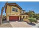 Exterior view of a two-story home featuring a red garage door and drought tolerant landscaping at 5662 Oak Bend Dr, Las Vegas, NV 89135