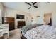 Neutral main bedroom features a dark wood dresser, TV, ceiling fan, and ensuite access at 5662 Oak Bend Dr, Las Vegas, NV 89135