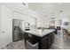 Modern kitchen with a center island, stainless steel appliances, and seamless flow to the dining and living areas at 5684 Benevento Ct, Las Vegas, NV 89141