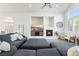 Cozy living room with built-in shelving, a fireplace, comfortable sectional sofa, and ample natural light at 5684 Benevento Ct, Las Vegas, NV 89141