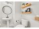 This powder room features a pedestal sink, floating shelves, and a modern toilet at 5684 Benevento Ct, Las Vegas, NV 89141