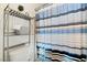 A simple, yet functional shower room with striped curtain, shelf, and basic fixtures at 5684 Benevento Ct, Las Vegas, NV 89141