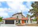 Charming two-story home with a terra cotta tile roof, and an inviting entrance featuring vibrant orange doors at 5757 Charles Holden Ct, Las Vegas, NV 89103