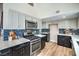 Bright kitchen features stainless steel appliances, gray and navy cabinets, and quartz countertops at 5757 Charles Holden Ct, Las Vegas, NV 89103