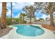 Refreshing backyard pool with mature palm trees and clear blue skies overhead at 5757 Charles Holden Ct, Las Vegas, NV 89103
