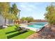 Backyard featuring artificial grass, lounge chairs, mature landscaping and a pool at 6315 Bellisima St, Las Vegas, NV 89118