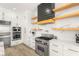 Close-up of a modern kitchen with a stainless steel range, open shelving, and white cabinets at 6315 Bellisima St, Las Vegas, NV 89118