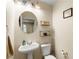 Bright half bathroom features a pedestal sink, decorative shelves, and ample lighting at 6488 Bentley Wood Ct, Las Vegas, NV 89130