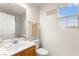 A bright bathroom with wood vanity, a window with blinds, a large mirror, and a shower/tub combo at 6488 Bentley Wood Ct, Las Vegas, NV 89130