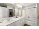 Large bathroom with double sinks, bright vanity lighting, shower/tub combo, and walk-in closet at 6488 Bentley Wood Ct, Las Vegas, NV 89130