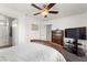 Comfortable bedroom featuring a wood bed frame, ceiling fan, carpeted floors, with access to a full bathroom at 6488 Bentley Wood Ct, Las Vegas, NV 89130