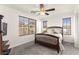 Relaxing bedroom featuring a wood bed frame, ceiling fan, carpeted floors, and bright windows at 6488 Bentley Wood Ct, Las Vegas, NV 89130