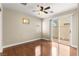 Well-lit bedroom featuring hardwood floors, a ceiling fan, and sliding glass doors to the backyard at 6488 Bentley Wood Ct, Las Vegas, NV 89130