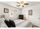 Bright bedroom featuring a ceiling fan, window, and dresser; access to ensuite bathroom at 6488 Bentley Wood Ct, Las Vegas, NV 89130
