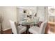 Open floor plan dining room features a glass table, hardwood floors, and access to other living spaces at 6488 Bentley Wood Ct, Las Vegas, NV 89130