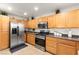 Well lit kitchen features wood cabinets, tile floors, stainless steel appliances, and dark countertops at 6488 Bentley Wood Ct, Las Vegas, NV 89130
