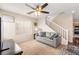 Carpeted living room with a gray sofa, stairway, and a ceiling fan at 6488 Bentley Wood Ct, Las Vegas, NV 89130