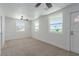 Bright bedroom with three windows, ceiling fan, and neutral carpet at 663 D Ave, Boulder City, NV 89005