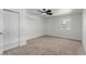 A bedroom featuring a ceiling fan, neutral carpet, and ample natural light from a window at 663 D Ave, Boulder City, NV 89005