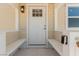 A close-up view of the home's front door with a sidelight, a new door, and a porch bench at 663 D Ave, Boulder City, NV 89005