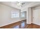 Spare bedroom featuring hardwood floors, ceiling fan, and closet with mirrored door at 6649 Maple Mesa St, North Las Vegas, NV 89084