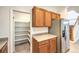 Kitchen view with stainless refrigerator, pantry, and wood cabinets at 6649 Maple Mesa St, North Las Vegas, NV 89084