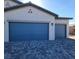 Two car garage with a cobblestone driveway, and desert landscaping at 73 Hawk Ave, Pahrump, NV 89060