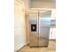 Stainless steel refrigerator with water dispenser complementing the white cabinets and granite countertops at 73 Hawk Ave, Pahrump, NV 89060