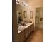 Bathroom featuring dual sinks, vanity lighting, and ample counter space next to the bath at 7400 W Flamingo Rd # 1090, Las Vegas, NV 89147