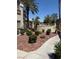 Exterior walkway with red rock landscaping and palm trees at 7400 W Flamingo Rd # 1090, Las Vegas, NV 89147