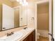 Well-lit bathroom with double sinks, dark cabinetry, and a view into the shower at 7434 Eggshell Dr, North Las Vegas, NV 89084