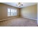 Spacious bedroom with neutral walls, plush carpet, a ceiling fan, a large window with shutters for ample natural light at 7434 Eggshell Dr, North Las Vegas, NV 89084