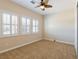 This carpeted bedroom features bright, natural light and a ceiling fan at 7434 Eggshell Dr, North Las Vegas, NV 89084