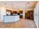 Open kitchen features stainless steel appliances, dark wood cabinets, pendant lighting and an island with counter seating at 7434 Eggshell Dr, North Las Vegas, NV 89084