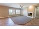 Bright living room featuring a cozy fireplace, tile and carpet flooring and white shuttered windows at 7434 Eggshell Dr, North Las Vegas, NV 89084
