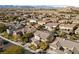 An aerial view of a neighborhood featuring beige two-story homes, desert landscaping and mountain views at 7438 Desertscape Ave, Las Vegas, NV 89178